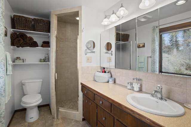 bathroom featuring tile patterned flooring, toilet, vanity, tasteful backsplash, and a stall shower