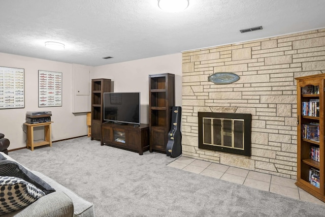 carpeted living room with a textured ceiling, a fireplace, and visible vents