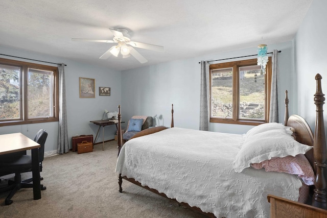 bedroom featuring ceiling fan, multiple windows, and carpet flooring