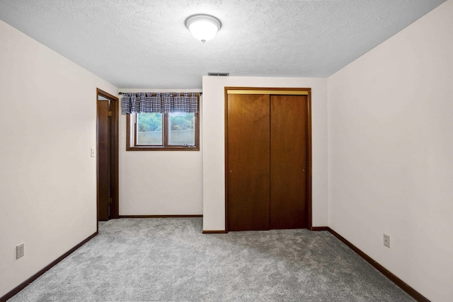 unfurnished bedroom with carpet, baseboards, visible vents, and a closet