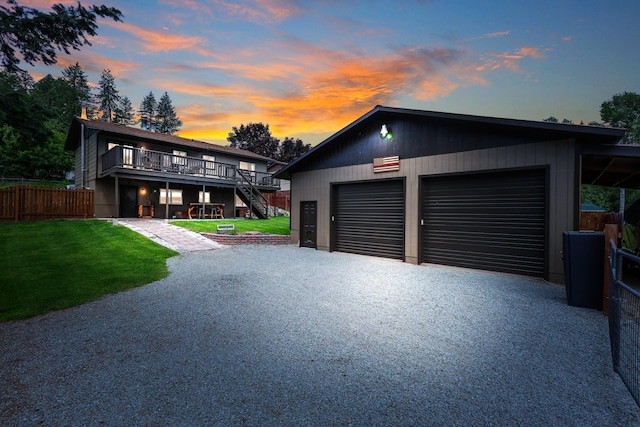 view of front of house featuring driveway, a lawn, stairway, and fence