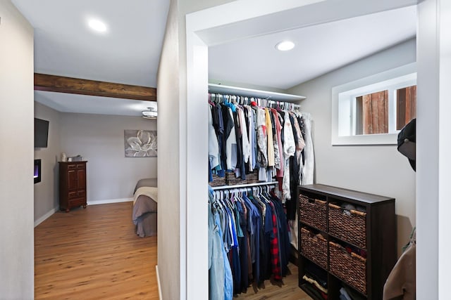 spacious closet with wood finished floors and beamed ceiling