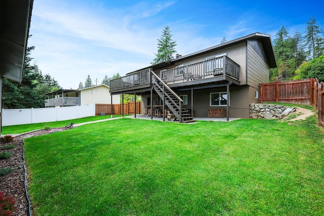 back of house with a fenced backyard, a yard, a deck, and stairs