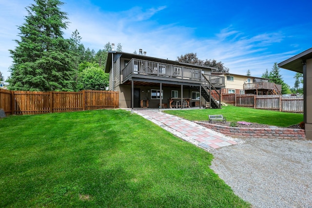 back of property with stairs, a lawn, a fenced backyard, and a wooden deck