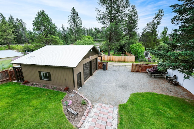 exterior space featuring a yard, metal roof, fence, and gravel driveway