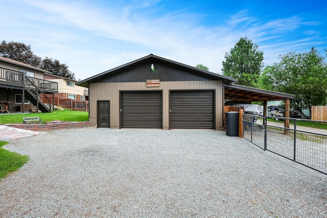 garage with driveway, a garage, and fence