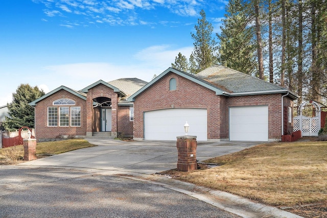 ranch-style house with a front yard, concrete driveway, brick siding, and an attached garage