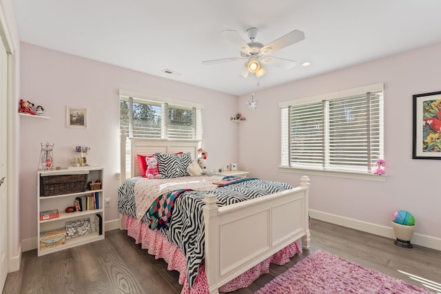 bedroom featuring visible vents, baseboards, wood finished floors, and a ceiling fan