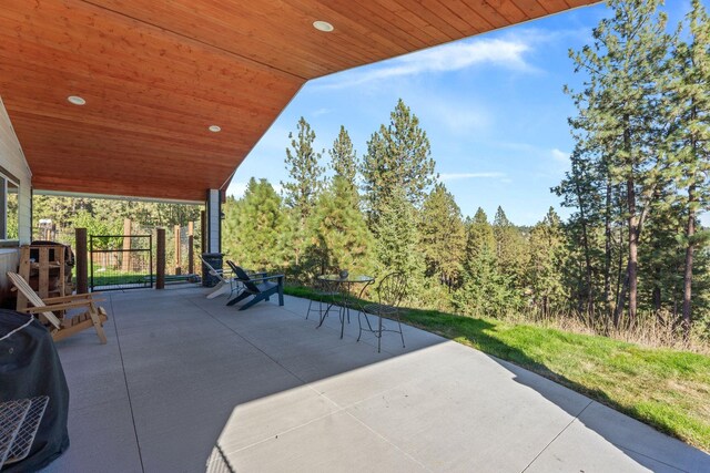 view of patio / terrace with area for grilling and a wooded view