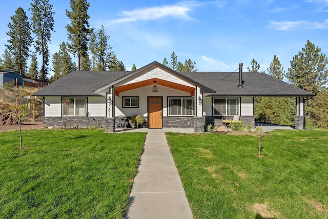 view of front of home featuring stone siding, covered porch, and a front lawn