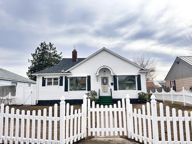 bungalow with roof with shingles, a gate, a fenced front yard, and a chimney