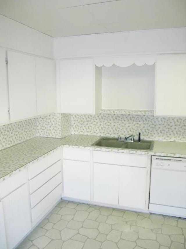 kitchen featuring a sink, white cabinets, light countertops, and white dishwasher