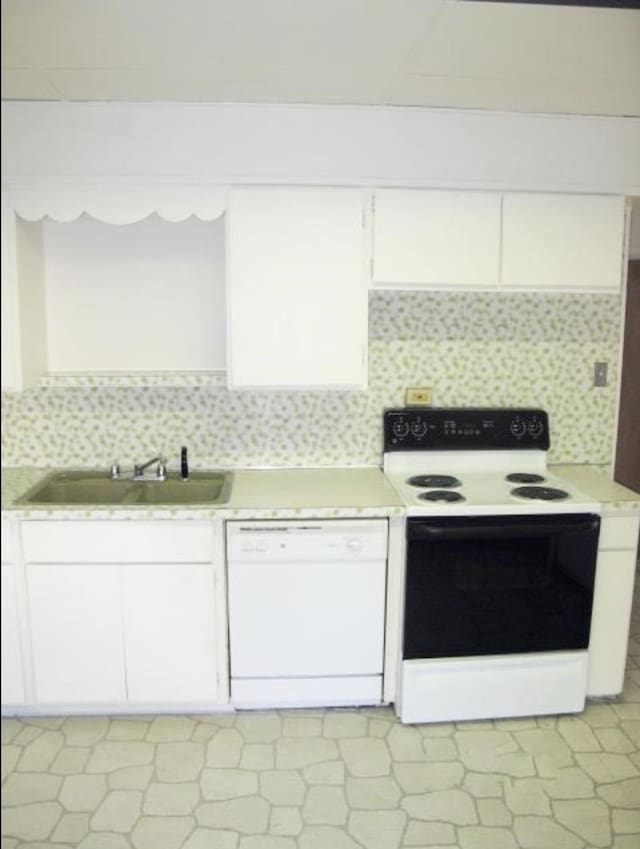 kitchen with dishwasher, light countertops, range with electric stovetop, and a sink