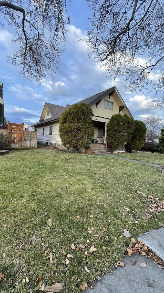 view of front of home with a front yard and fence