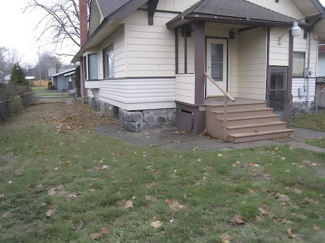 view of front facade featuring a chimney, a shingled roof, and a front lawn