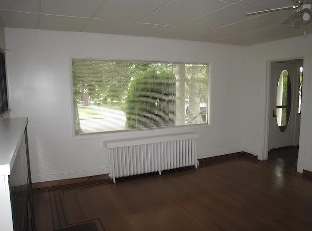 interior space with plenty of natural light, radiator, baseboards, and wood finished floors