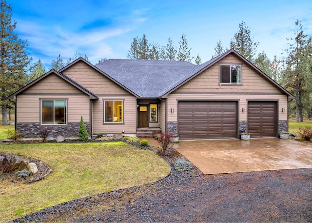 view of front of property with stone siding, a front lawn, roof with shingles, and driveway