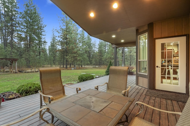 wooden deck featuring outdoor dining space and a yard