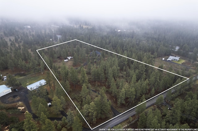 birds eye view of property with a view of trees