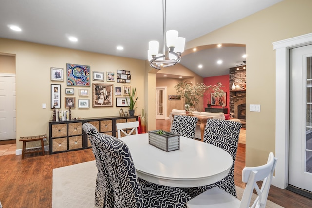 dining space with recessed lighting, wood finished floors, and vaulted ceiling