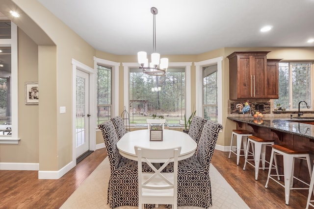 dining area with an inviting chandelier, dark wood-style floors, and baseboards