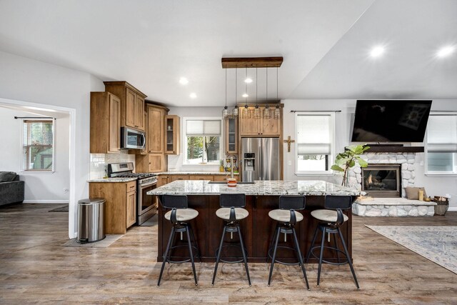 kitchen featuring brown cabinetry, open floor plan, appliances with stainless steel finishes, and a kitchen island