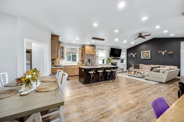 dining space with a ceiling fan, vaulted ceiling, recessed lighting, and light wood-type flooring