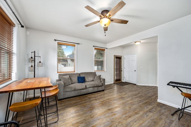 living area with hardwood / wood-style flooring, baseboards, and ceiling fan