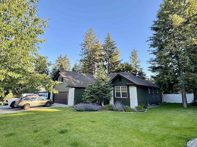 view of front of property with a garage, concrete driveway, a front yard, and fence