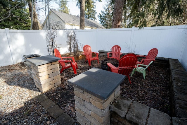 view of patio featuring a fenced backyard and a fire pit