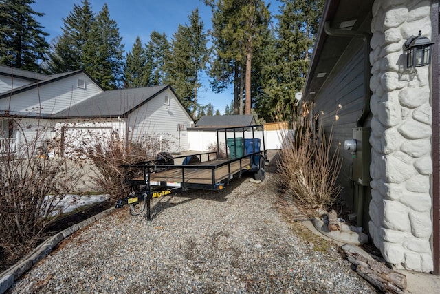 view of side of home with an outbuilding and fence