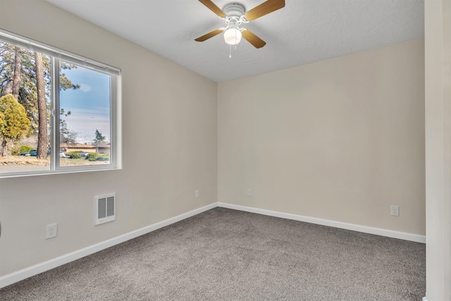 unfurnished room with visible vents, a healthy amount of sunlight, baseboards, and carpet floors