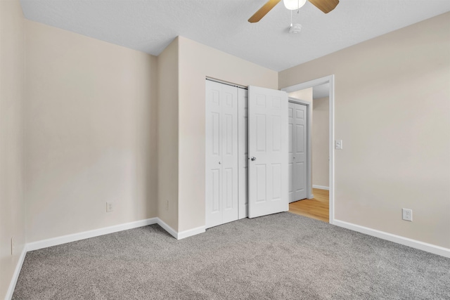 unfurnished bedroom with a closet, baseboards, carpet, and ceiling fan