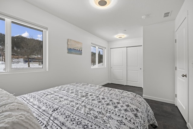 bedroom with a closet, visible vents, and baseboards