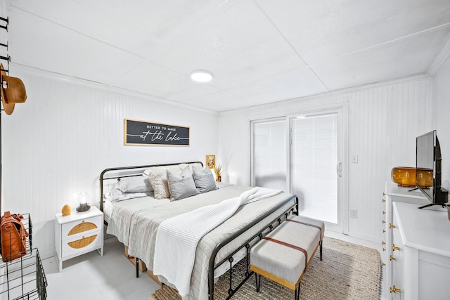 bedroom with crown molding, access to outside, and concrete flooring