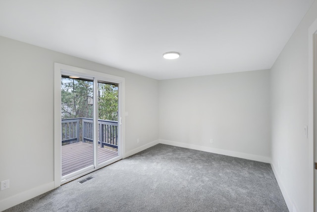 carpeted spare room featuring baseboards and visible vents