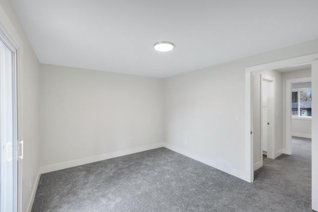 carpeted spare room featuring baseboards