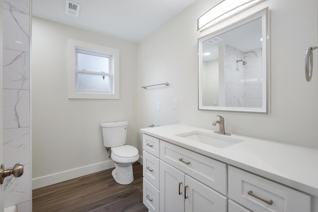 full bath featuring visible vents, toilet, wood finished floors, baseboards, and vanity