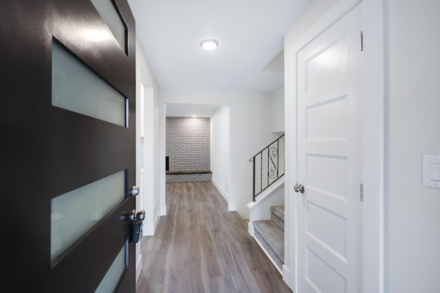 hallway with stairway, wood finished floors, and baseboards