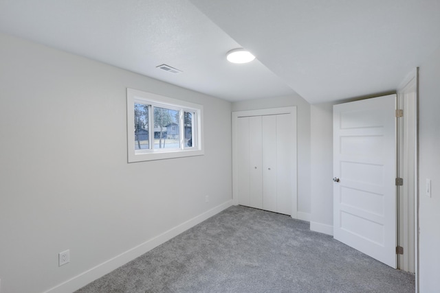 unfurnished bedroom featuring visible vents, baseboards, carpet, and a closet