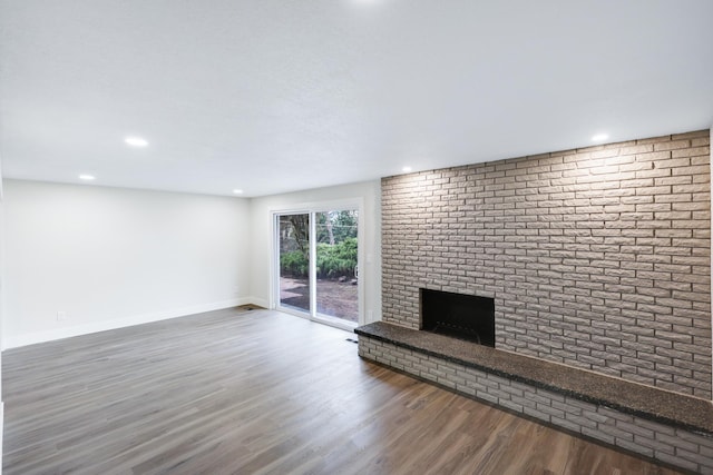 unfurnished living room featuring a fireplace, recessed lighting, wood finished floors, and baseboards