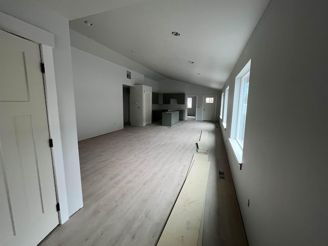 unfurnished living room featuring light wood-style flooring and lofted ceiling