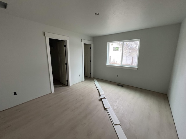 empty room featuring visible vents and light wood-style floors