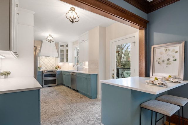 kitchen featuring custom exhaust hood, decorative backsplash, stainless steel appliances, and light countertops