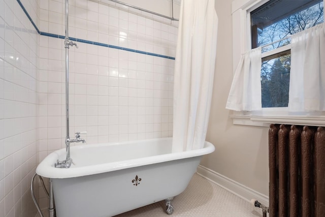 full bathroom featuring a freestanding bath, radiator heating unit, and baseboards