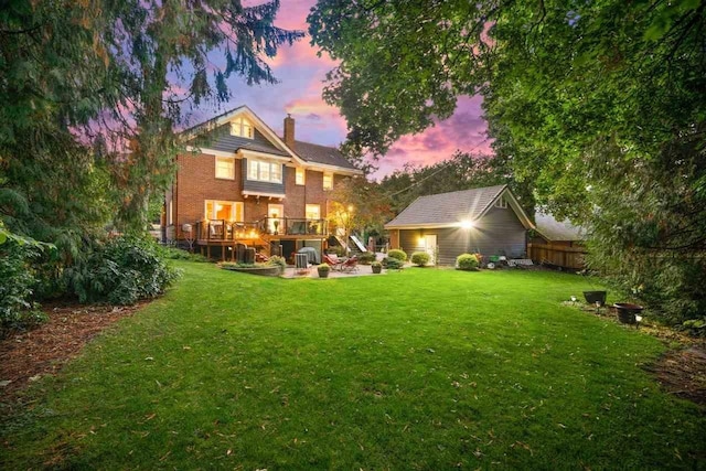 back of house with a lawn, a chimney, a patio, a wooden deck, and stairs