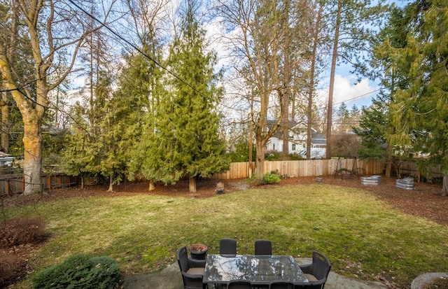 view of yard with outdoor dining space and a fenced backyard