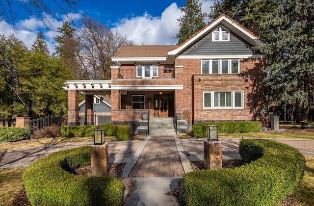 view of front of house featuring a balcony, a porch, and brick siding