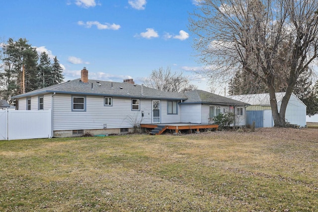 back of house featuring fence, a yard, a shingled roof, a wooden deck, and a chimney