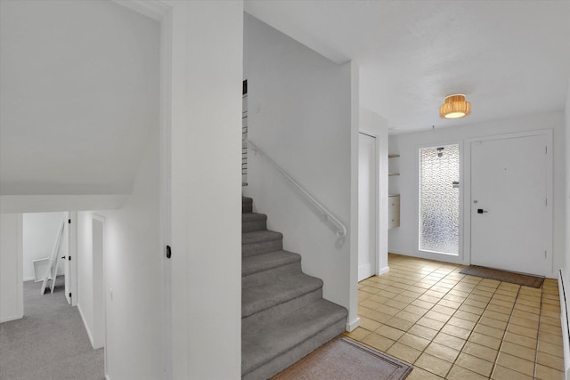 foyer featuring stairs, baseboards, and tile patterned flooring